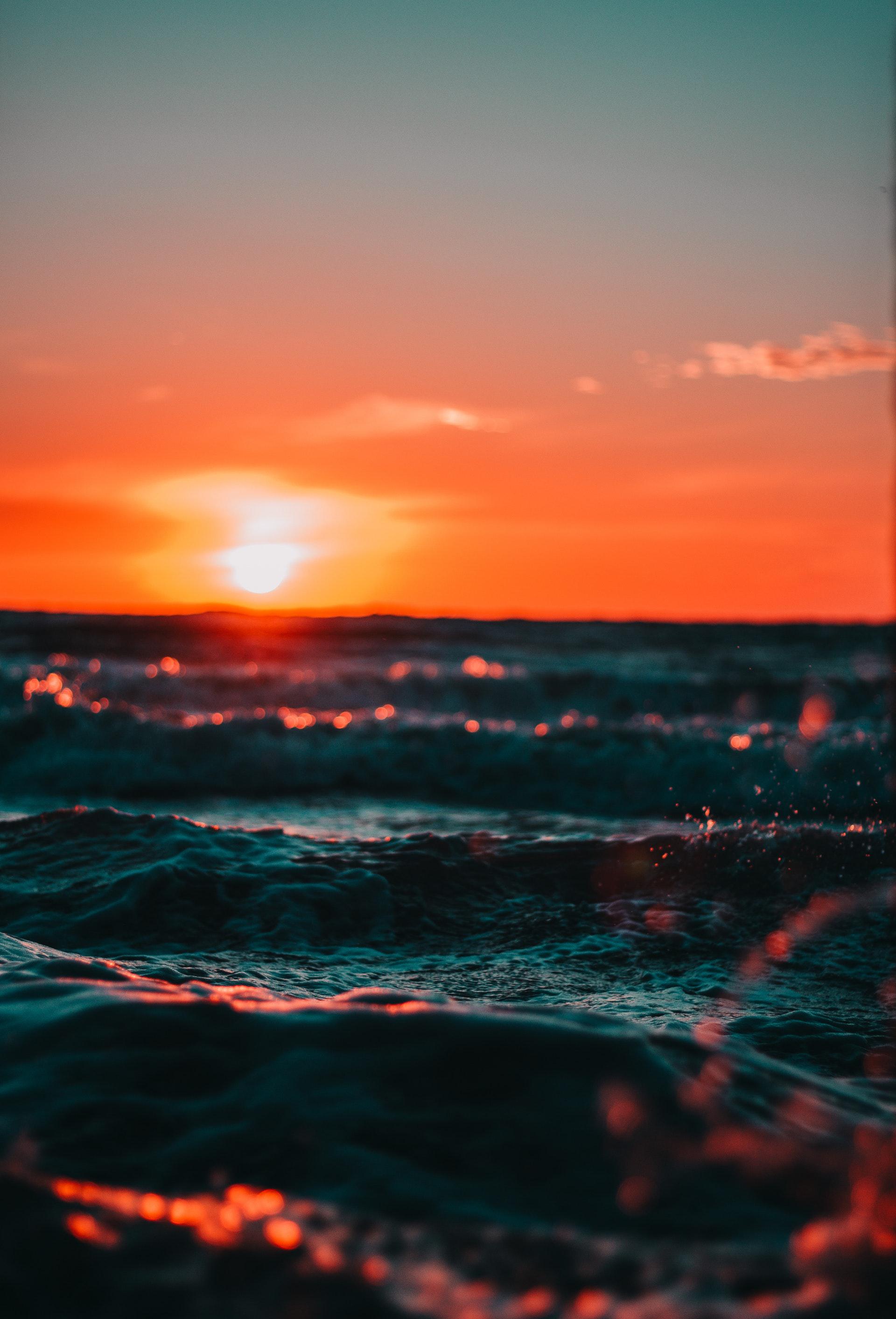 عکس زمینه نمای اقیانوس در غروب آفتاب پس زمینه