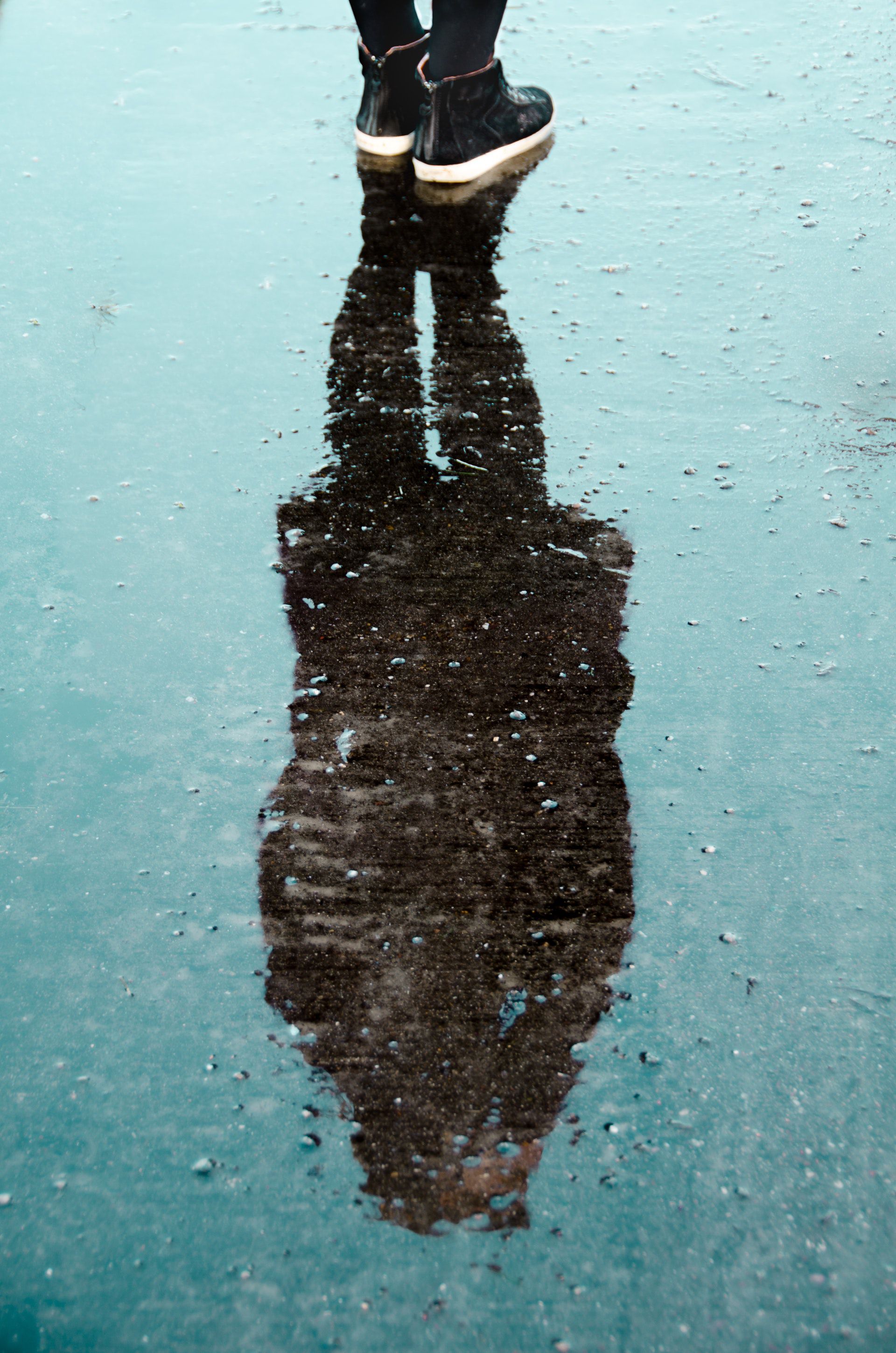 عکس زمینه سایه شخص روی سطح آب زمین بارانی پس زمینه